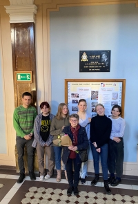 Milena Šatavová in 2022 with students at the Pierre de Coubertin Grammar School under the memorial plaque of Gen. Karel Mareš