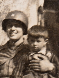 Roland Waclav as a child in the lap of an American soldier, Všeruby, May 1945