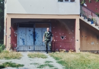 In front of a shot-up family house, Bosnia and Herzegovina, 1999