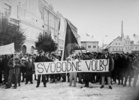 Witness with a banner of Free Elections (holding the banner on the left, his wife Hana in the middle above the inscription "elections") on the square in Frýdlant during the Velvet Revolution, November 1989