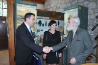 Petr Kadleček shakes hands with Martin Půta, the Governor of the Liberec Region, in the Šindelka Museum in Harrachov, with Eva Zbrojová, the former mayor of Harrachov, standing in the back. 2010s