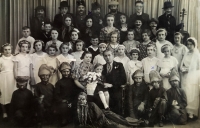 The witness in a photo from a school performance at the municipal school in Austria (marked with a cross in the second row, her older sister Jarmila in the top row with a pipe also marked with a cross, in the middle the class teacher Karel Pribyl with his wife and son)