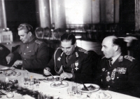 Heliodor Píka (right) is already in the division general rank, dating the photo back to early October 1945. Another possible clarification is the Yugoslav Order of the Partisan Star on the right side of his chest. Broz-Tito decorated Minister Svoboda and a group of Czechoslovak generals personally during his visit to Prague in April 1946. However, Píka may have received the decoration earlier. This dates the photograph to the period from October 1945 to April 1946. In addition to Píka, the photograph shows an as-yet unknown Romanian division general, a likely unidentifiable Soviet colonel, and the shoulder of a Romanian brigadier general. Judging by the plates, cutlery and food scraps (likely roast pork with dumplings and cabbage) I guess the lunch took place in our country. The Romanian division general is wearing the Soviet Suvorov Order (probably 2nd class) and the 1939 Czechoslovak War Cross. This makes him most certainly the commander of the Romanian division or corps that was deployed to liberate Czechoslovakia in 1945. Only such top commanders received Soviet orders of this level. Jiří Fidler, Institute of History, Armed Forces of the Czech Republic