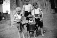 Karel Matuška with harmonica. Brothers Erhard with violin, Emerich with trumpet, Alfred with air rifle